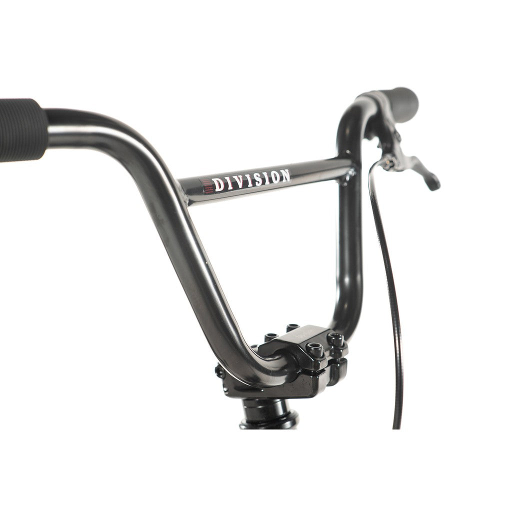 A close-up of the black bicycle handlebars prominently displays the brand name "Division Blitzer" from the Division Blitzer 14 Inch Bike. The image also highlights the detailed brake lever and cable, emphasizing features of this entry-level Freestyle BMX bike.