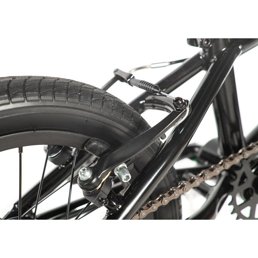 Close-up view of the Division Blitzer 14 Inch Bike's rear wheel brake mechanism, featuring the brake caliper, tire, chain, and part of the frame.