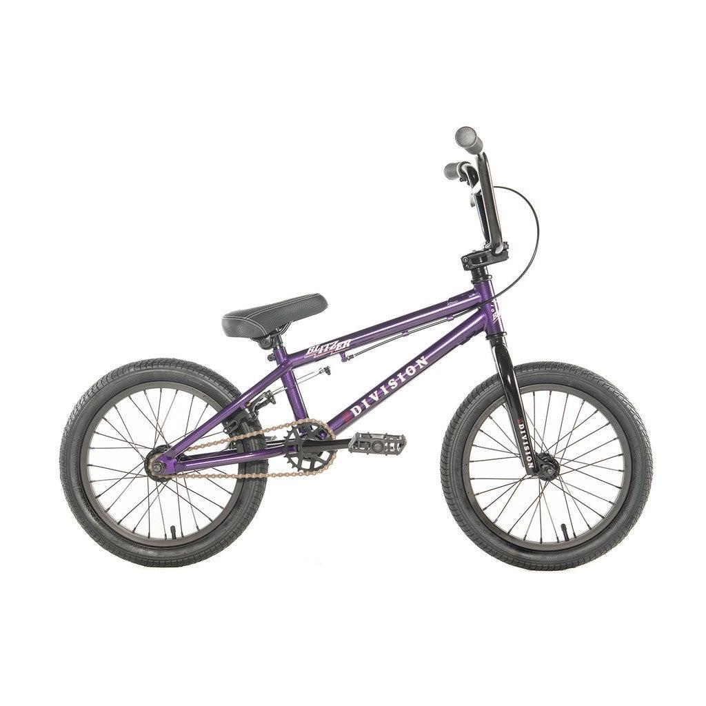 The Division Blitzer 16 Inch Bike is an entry-level BMX bicycle in purple, featuring a black seat, handlebars, and tires with a white "Division" logo on the frame. Ideal for kids!