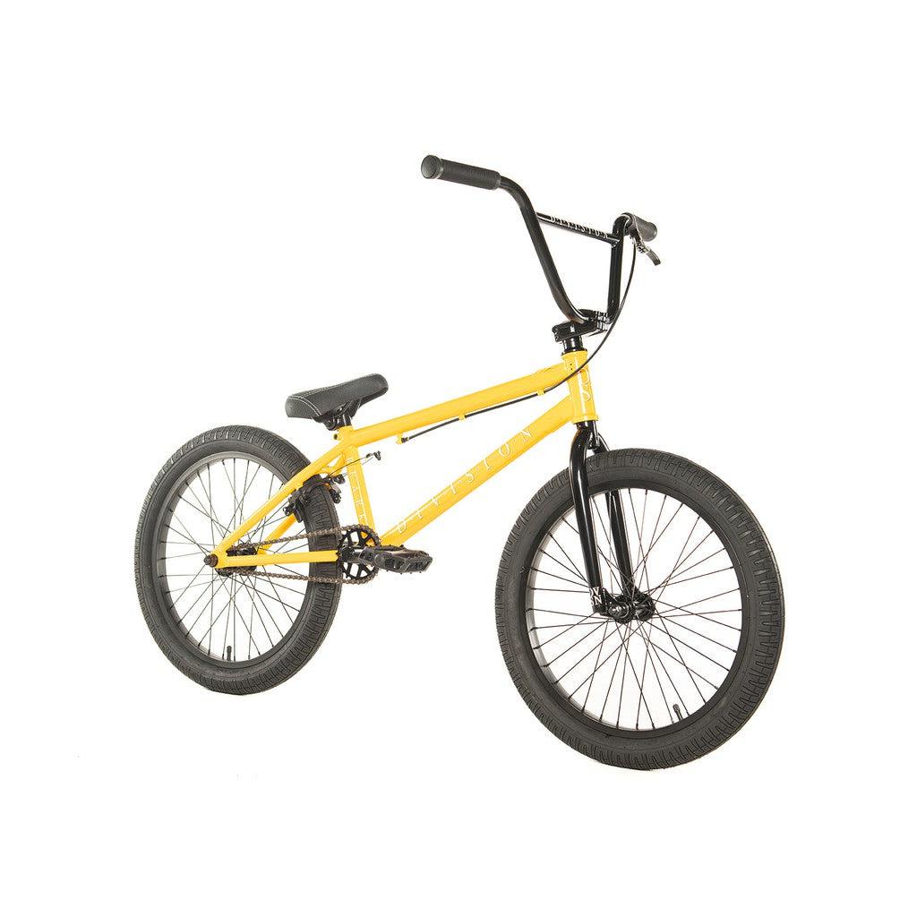 The Division Reark 20 Inch Bike is a sleek yellow BMX model made from Hi-Tensile steel, featuring a black handlebar and seat. It's equipped with durable 3-piece cranks and is set against a crisp white background.