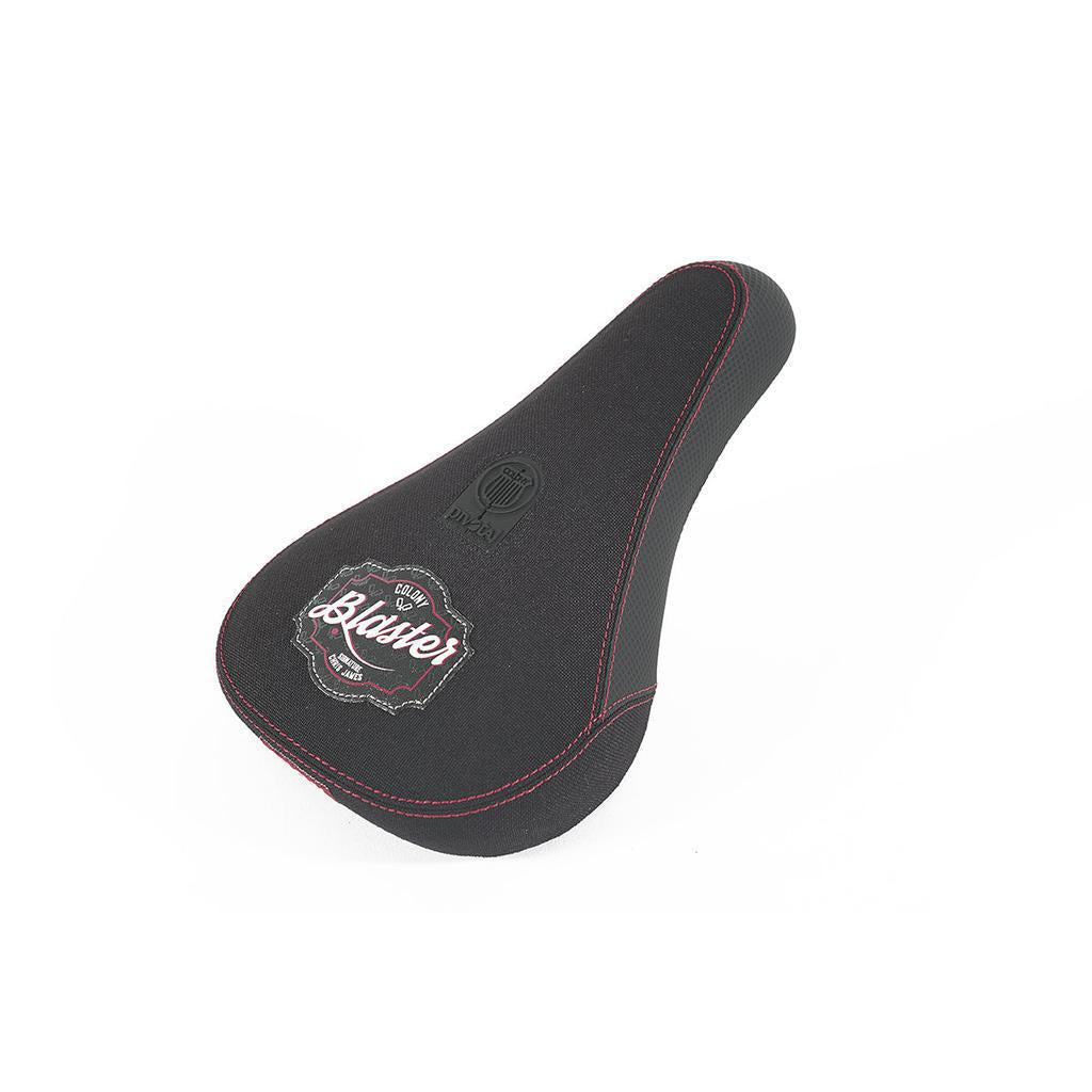 The Colony Blaster Fat Pivotal Seat in black and red features embroidered "Blaster" and "DRIVEN" logos. It's part of the exclusive Chris James signature collection, designed for style and performance.