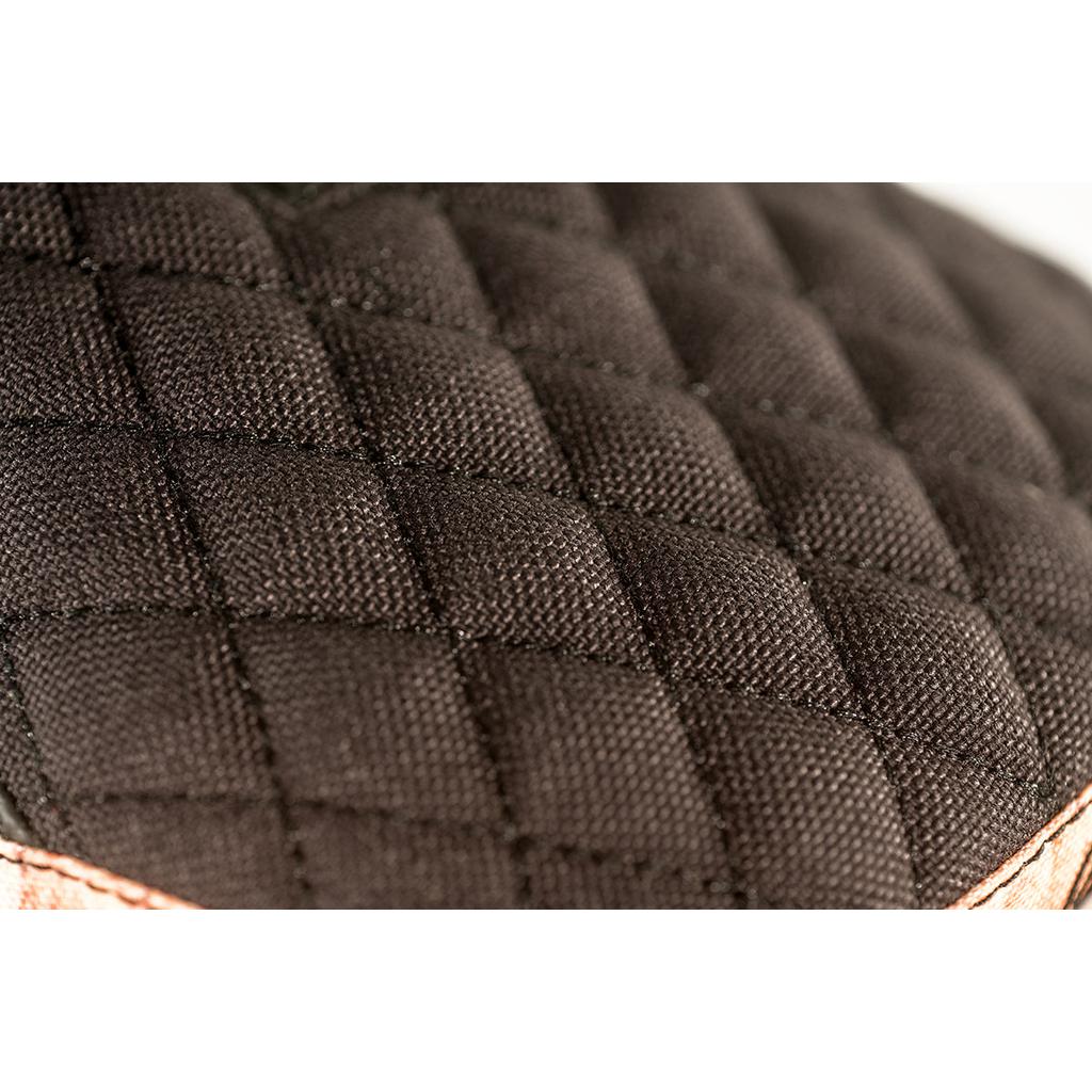 Close-up of black quilted fabric featuring Colony Wallwork Pivotal Seat's signature diamond stitching, highlighting intricate details reminiscent of Jake Wallwork's craftsmanship.