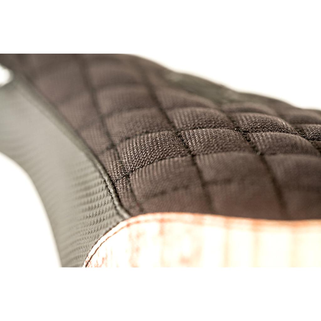 Close-up of the Colony Wallwork Pivotal Seat's textured, quilted fabric surface with black and grey diamond stitching, highlighted by a light brown edge.