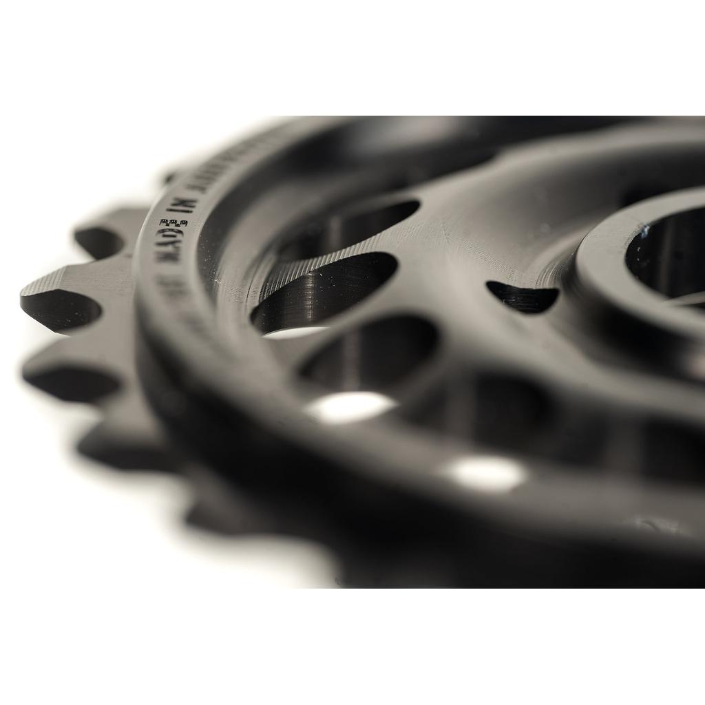 Close-up of Colony Pursuit Sprocket, a black BMX gear with multiple holes and teeth, highlighting the CNC machined aluminum texture and circular design.