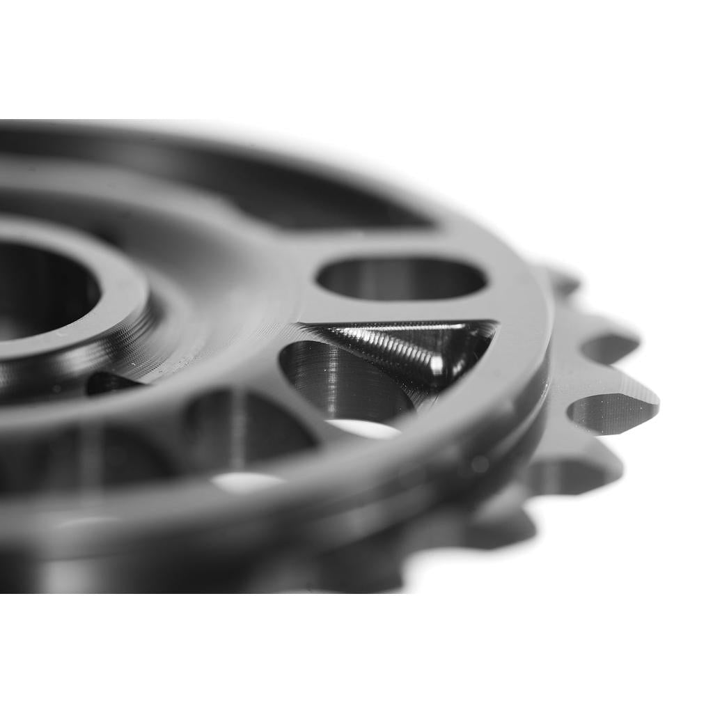 Close-up of a CNC machined aluminum gear with circular cutouts and edge teeth against a white background—an outstanding feature of the Colony Pursuit Sprocket.