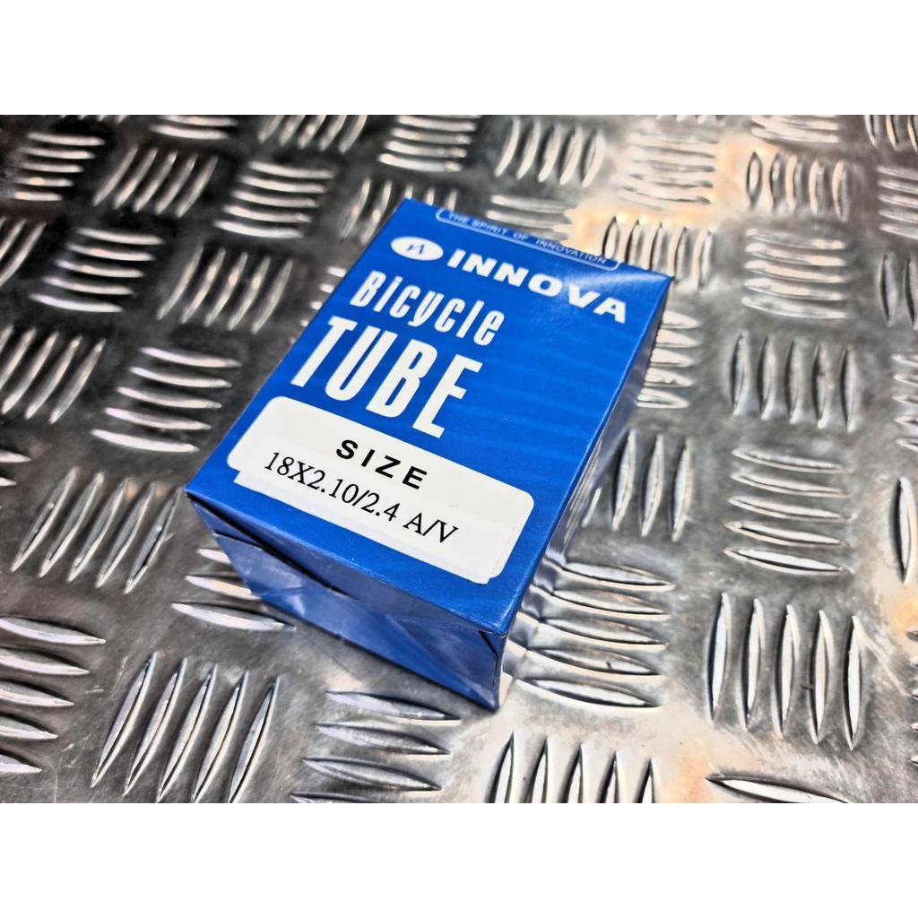 A blue box labeled "INNOVA Bicycle Tube Size 18x2.10/2.4 AV" sits on a metallic, textured surface, perfect for BMX riders looking for durable Colony Tube with a dependable Schrader valve system.