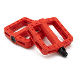 Displayed against a white background are two red Cinema Tilt Pedals, each featuring textured surfaces and black axle connectors. Their zero offset design and traction pins provide a secure grip while riding.