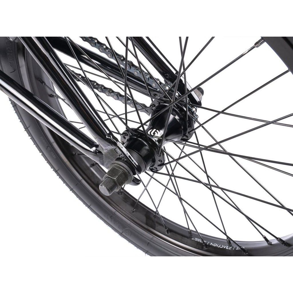 Close-up of a Wethepeople CRS FS 18 Inch BMX bike wheel with black spokes, tire, hub, and chainring on a plain white background.