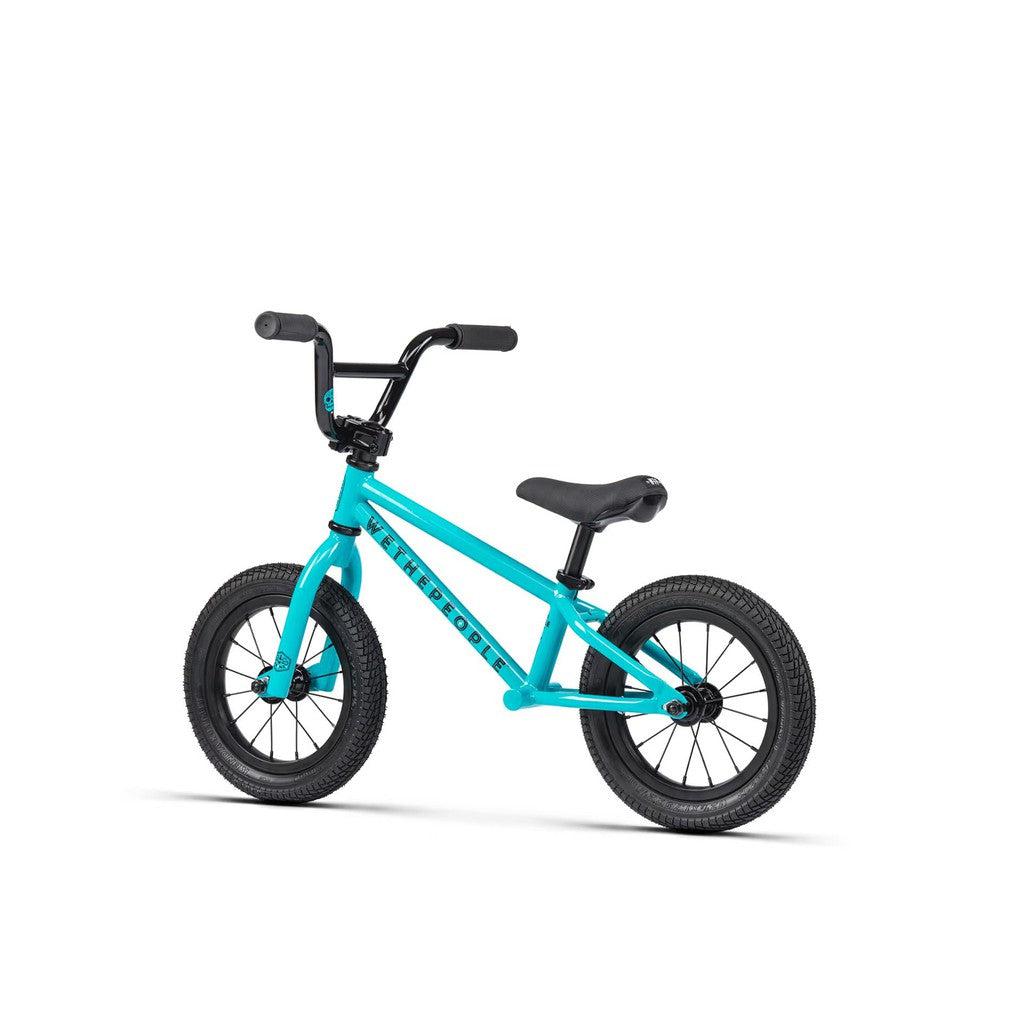 The Wethepeople Prime turquoise balance BMX bike, with black handlebars, seat, and wheels, is perfect for young children to develop balancing skills and ensures a smooth ride for every learner.