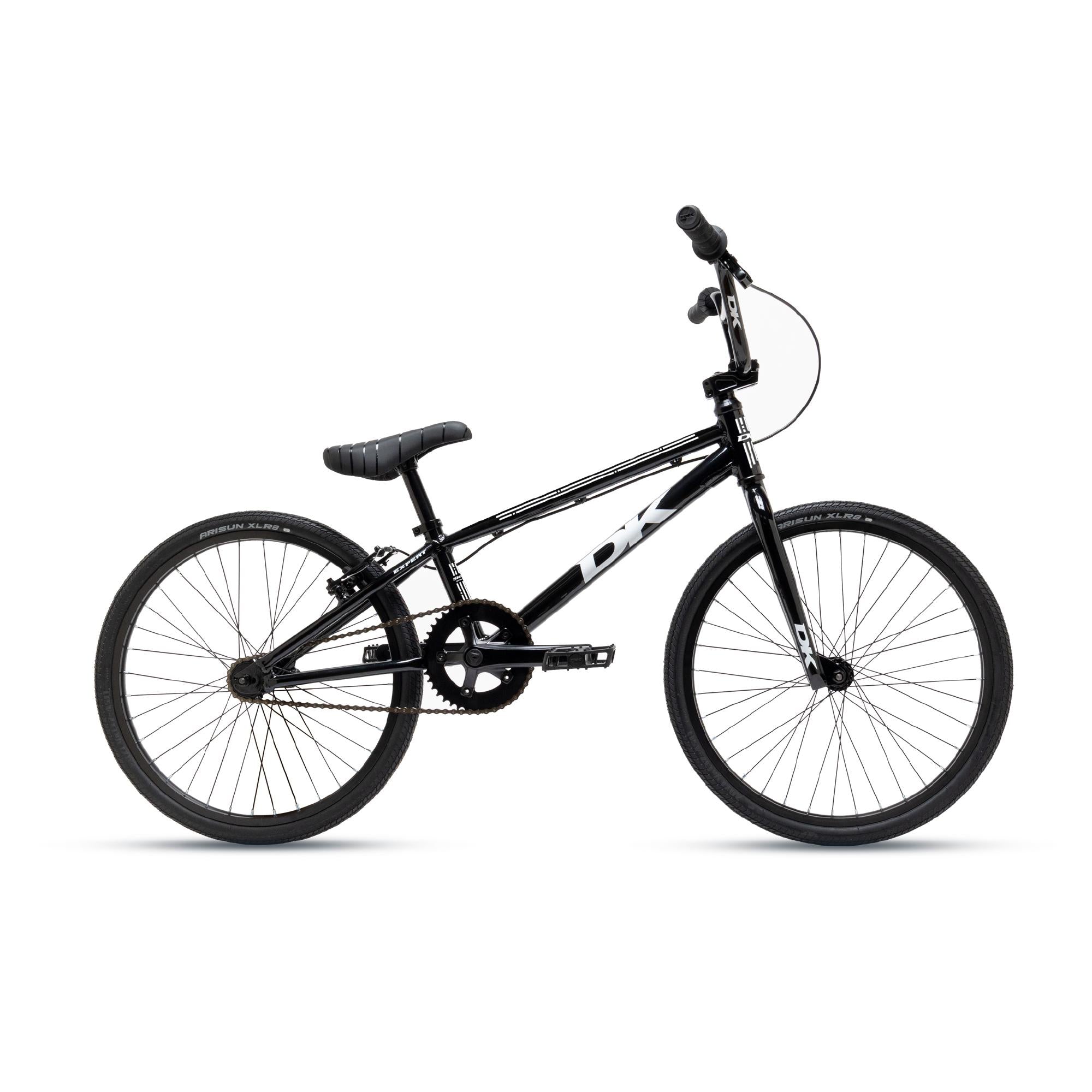 A black DK Swift Expert Bike, featuring a sleek frame, flat handlebars, and knobby tires, is elegantly positioned against a plain white background.