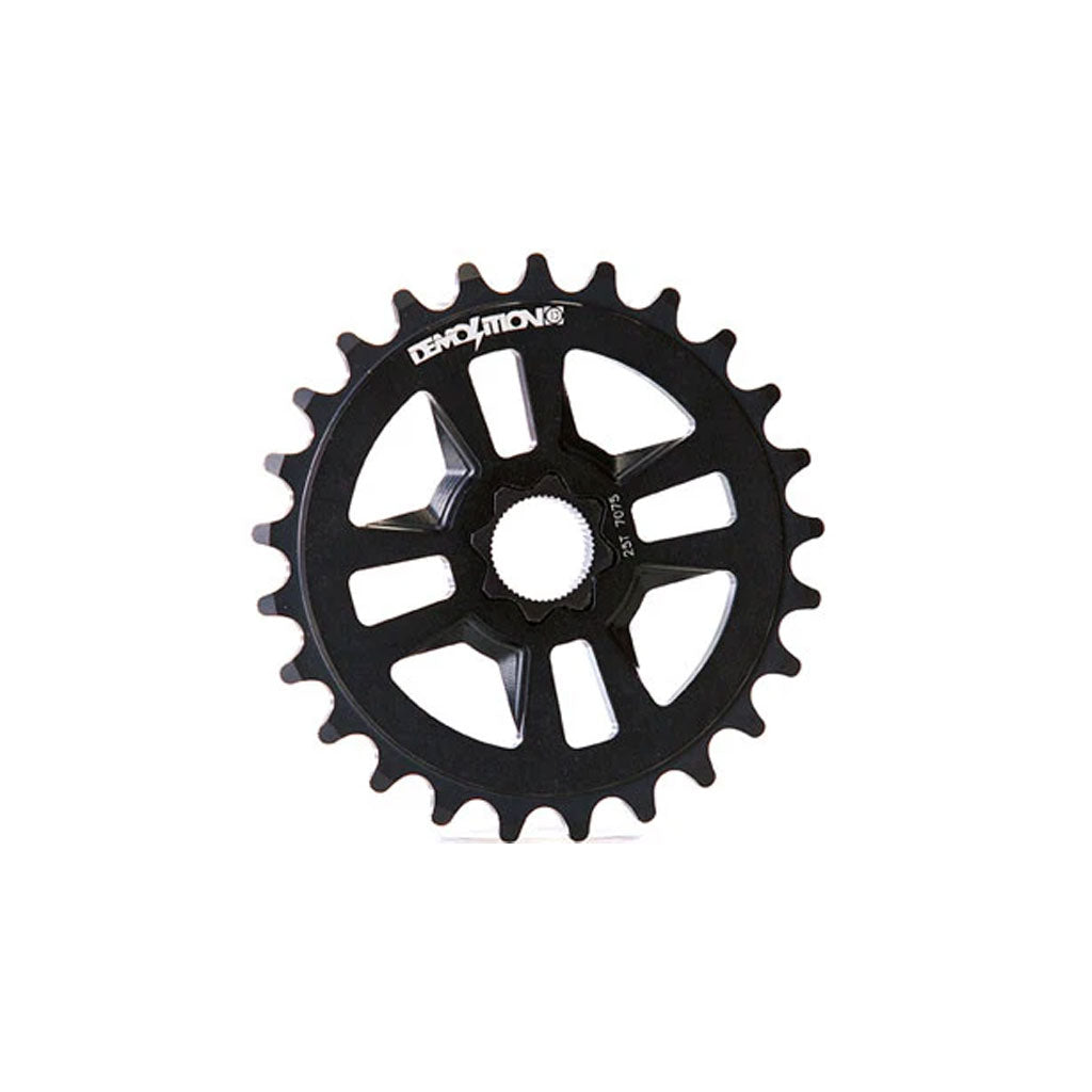 The Demolition Team Sprocket is a black BMX bike sprocket made from CNC'd 7075 alloy, with the brand name "Demolition" engraved on it. It features 25 teeth and an eight-spoke design around the center.