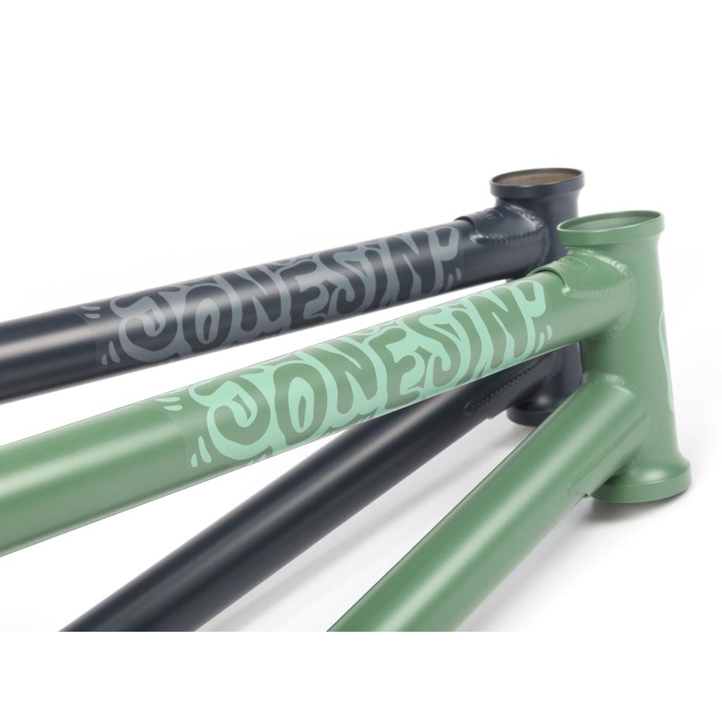 Three BSD Jonesin (2021) frames, featuring Sam Jones’ signature street-oriented geometry, are stacked diagonally—one green and two black.