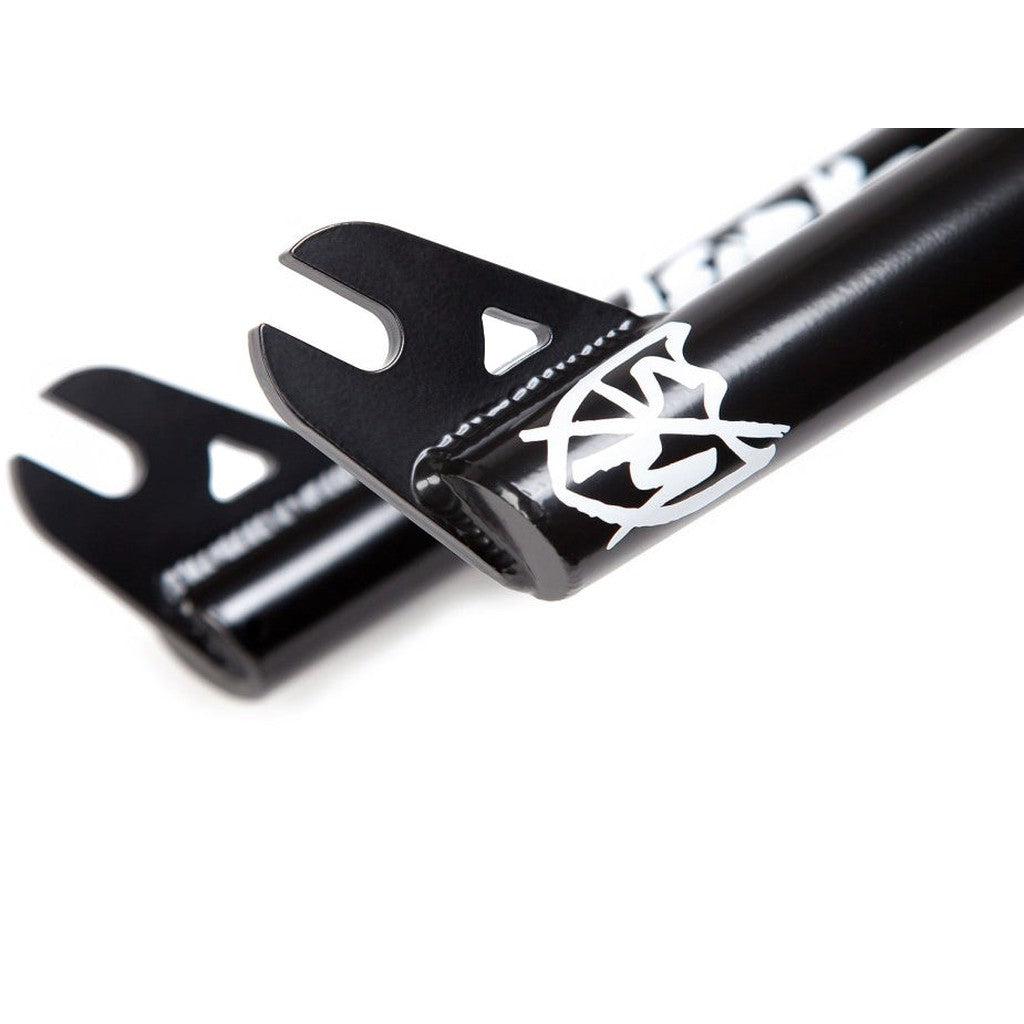 Close-up of the black S&M Widemouth 20 Inch Forks dropouts, showcasing a white logo and graphic design, ideal for fitting a BMX tire.