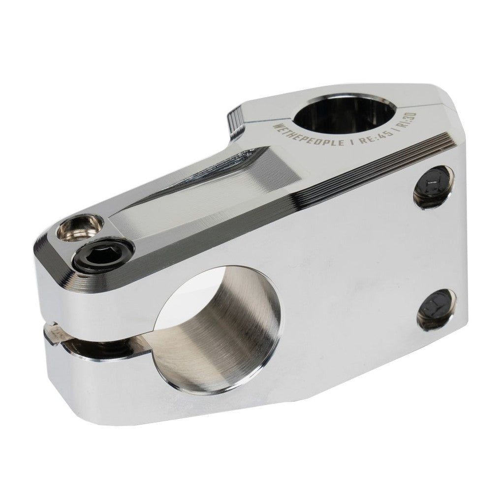 The Wethepeople Kira (Keiryo Kudo) Top Load Stem is a silver metal bike stem with bolt holes, engraved text on top, and boasts a Shark Tooth Clamping system for enhanced grip.