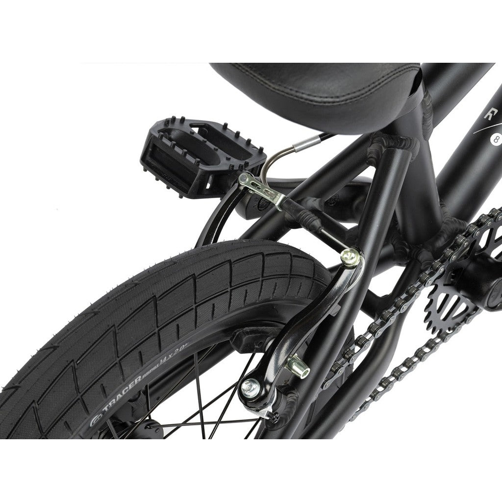 Close-up view of a black 14" Radio Dice 14 Inch Bike's rear frame, featuring the tire, chain, pedal, and brake mechanism. The lightweight kids bike boasts a durable 6061-T6 alloy frame for a robust yet smooth riding experience.