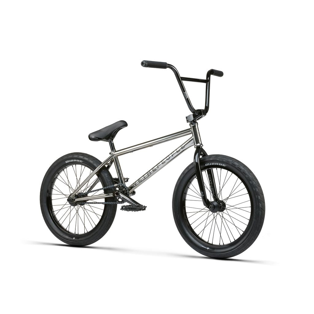 The Wethepeople Envy 20 Inch BMX Bike features a sleek silver chromoly frame, black handlebars and seat with thick black tires, and a chain drive system, all set against a plain white background.