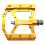 HT AE05 Pedals (Alloy / CNC CRMO) in yellow are crafted with CNC aluminum and metal studs, showcasing an open frame design. They include EVO+ bearings for seamless performance and a threaded axle for effortless installation. The pedals, featuring the brand logo, also come with replaceable pins for enhanced versatility.