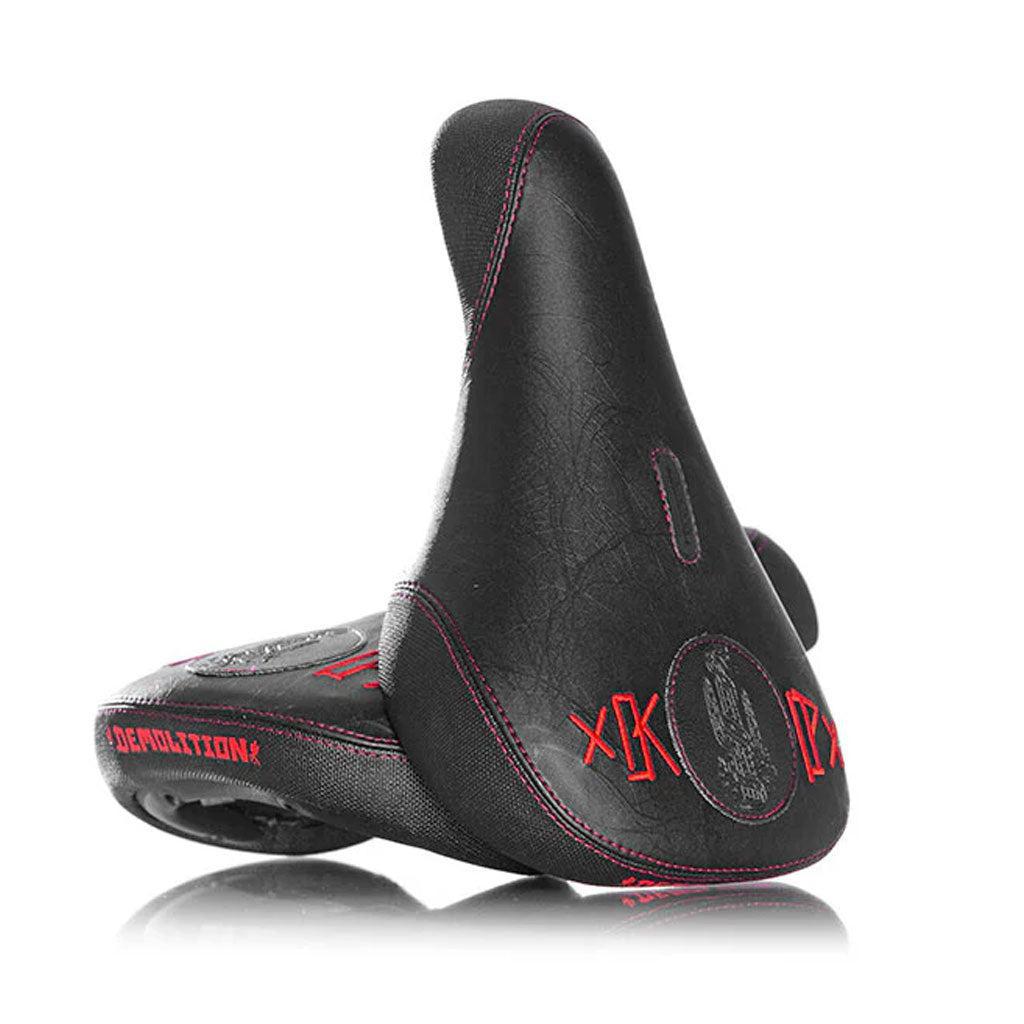 A black Demolition Kevin Peraza Pivotal seat with red stitching and logo designs, reflecting his signature style.