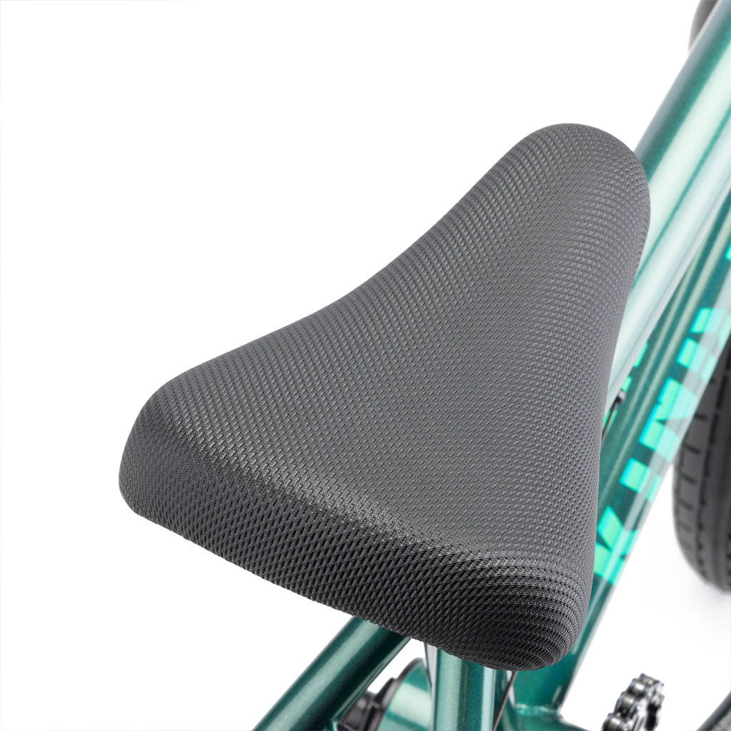 Close-up view of a black textured bicycle seat attached to a teal Kink Pump 14 Inch Bike (2025) frame.