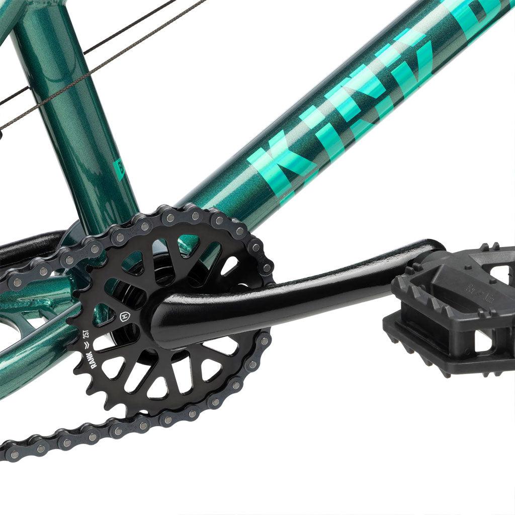 Close-up of a bicycle crankset and pedal on a green Kink Pump 14 Inch Bike (2025) frame with the brand name partially visible.