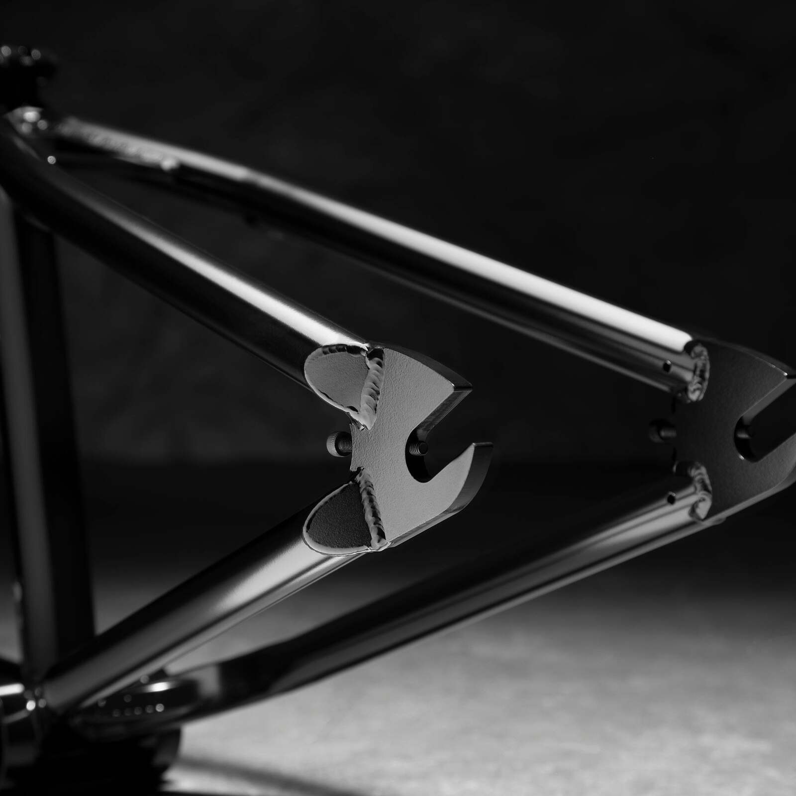 Black-and-white close-up of the Kink Roll Up Frame's rear dropout features intricate welds, emphasizing its street geometry design.