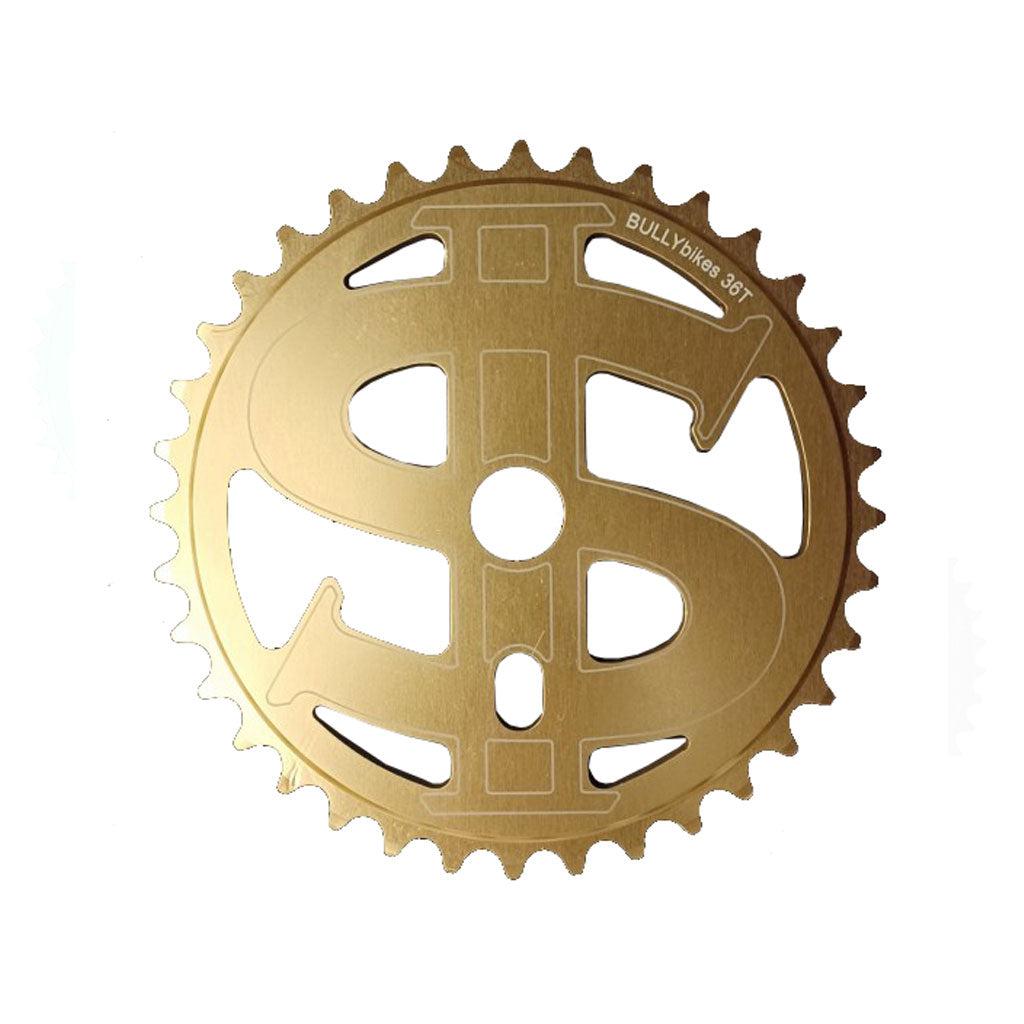 The MCS Bully Big Money Chainwheel is a gold-colored accessory crafted from 6061 aluminum alloy, designed in the shape of a dollar sign and engraved with the words "BULLYokes 38T." It's perfect for Bully Bikes BMX enthusiasts seeking both style and performance.