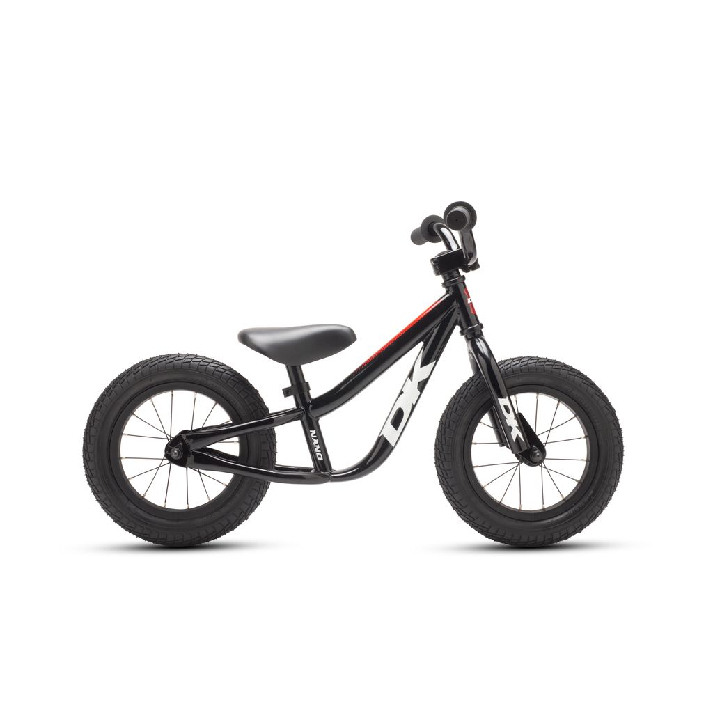 Introducing the DK Nano Balance Bike in sleek black, featuring robust tires, a unique curved frame, and a pedal-free design. Perfectly suited for young children to master their balance before moving on to pedal bikes, it's an excellent choice for beginners getting started with BMX biking experiences.