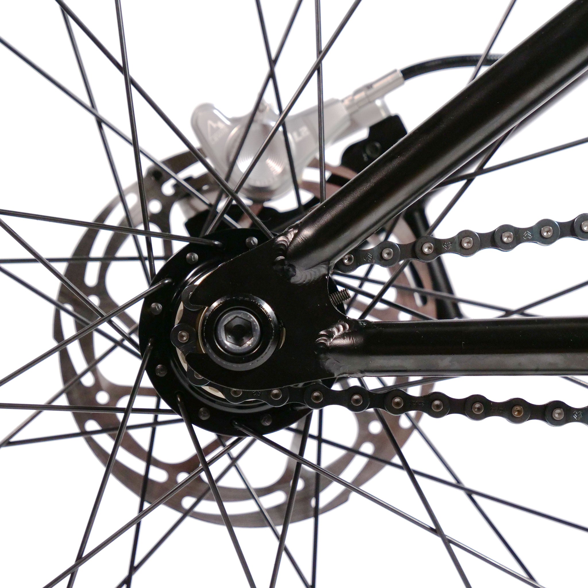 Close-up of a Wethepeople Chaos Machine 22 Inch Custom Bike wheel showing the spokes, disc brake rotor, chain, and part of the frame.