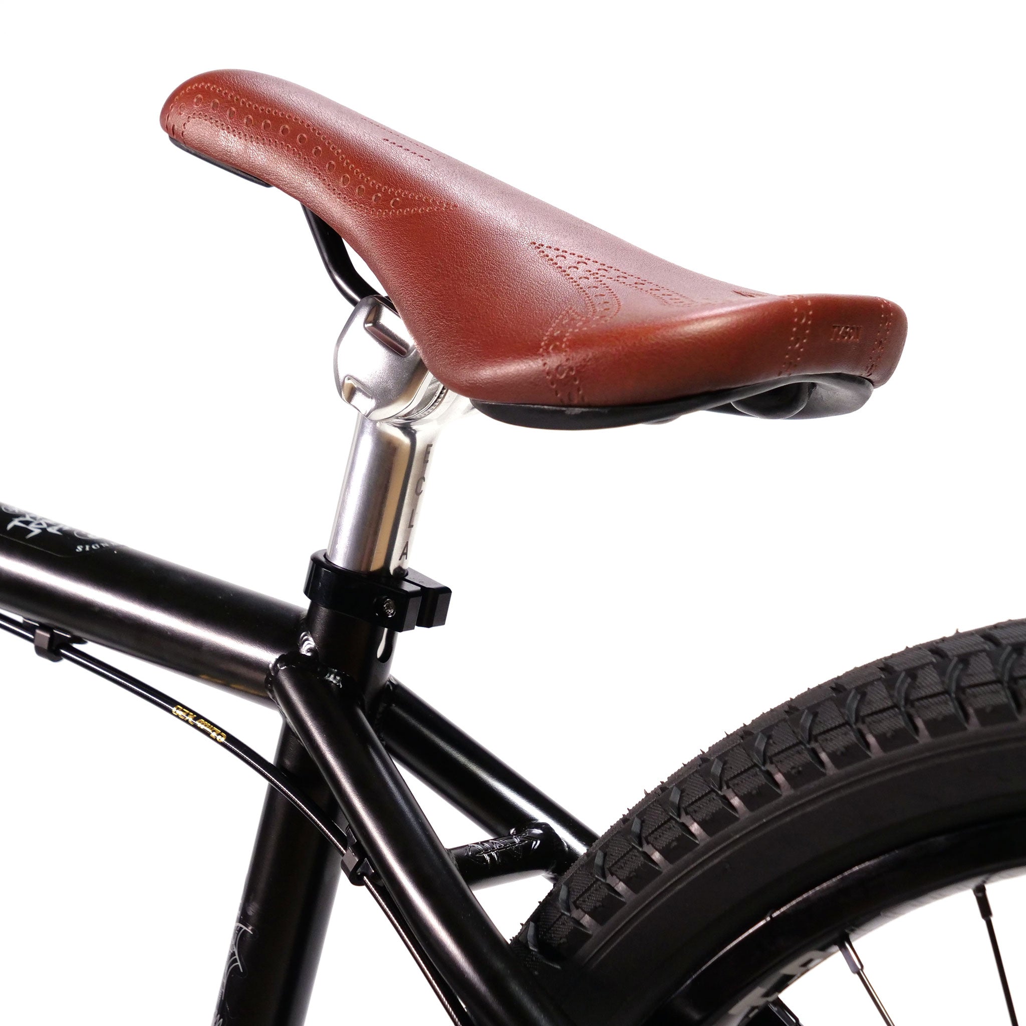 Close-up of an Eclat Exile bicycle seat with a brown leather cover, mounted on a sleek Wethepeople Chaos Machine 22 Inch Custom Bike frame.