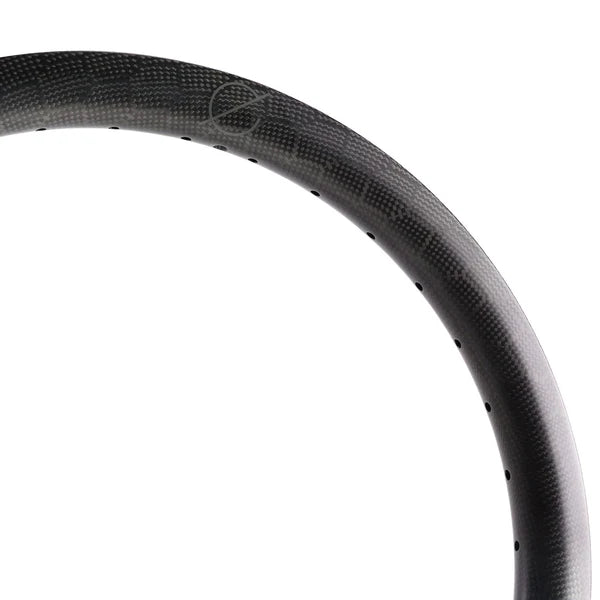 Close-up of a Spectre V2 Carbon Fiber 24-Inch Brakeless Rim in matte black, highlighting spoke path optimization through small, evenly spaced holes around the 36H rim.