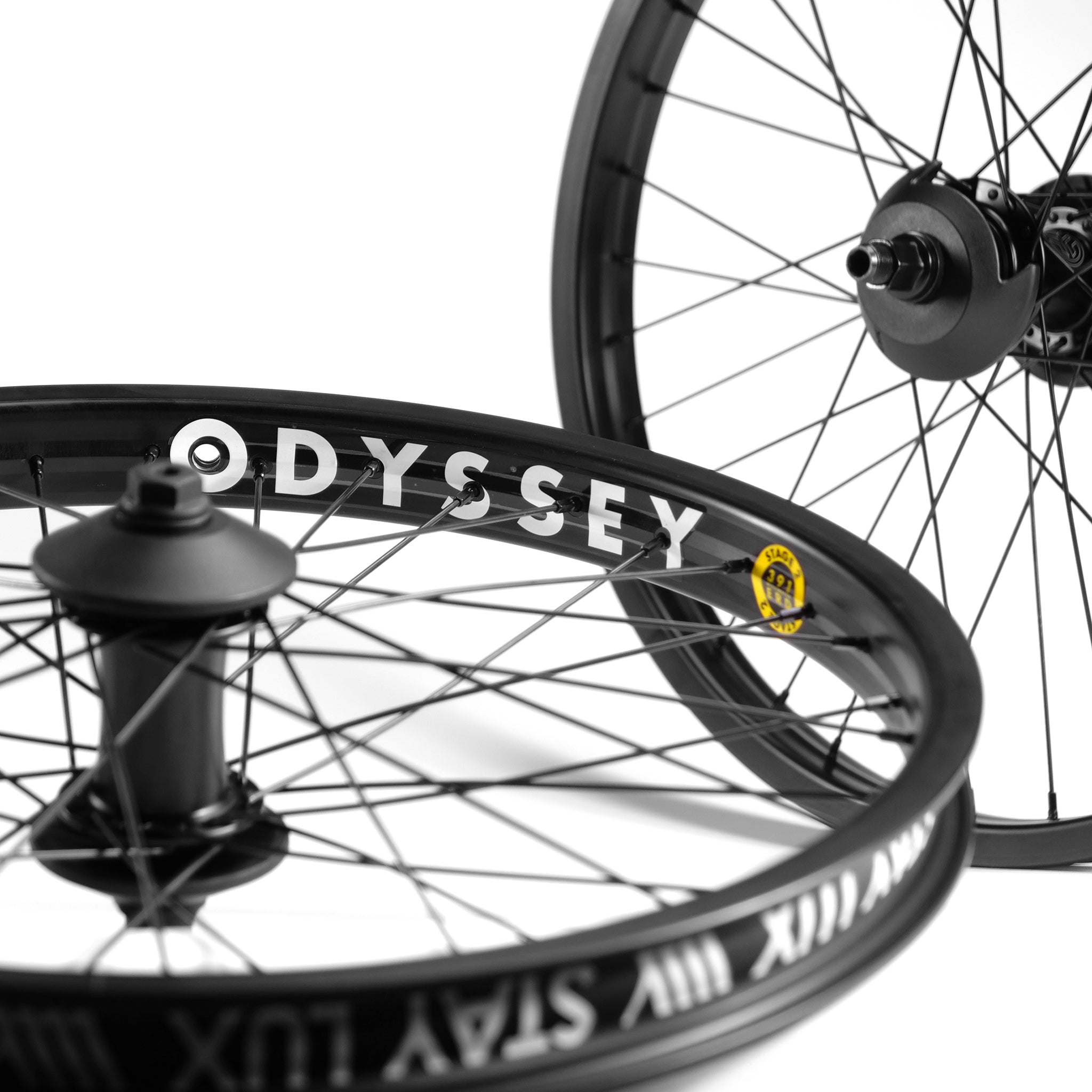 A close-up view of two bicycle wheels with black spokes, featuring a Federal Motion x Odyssey Stage 2 Custom Wheelset. The word "ODYSSEY" is printed in white on one of the rims, reminiscent of the sleek designs Boyd Hilder favors.