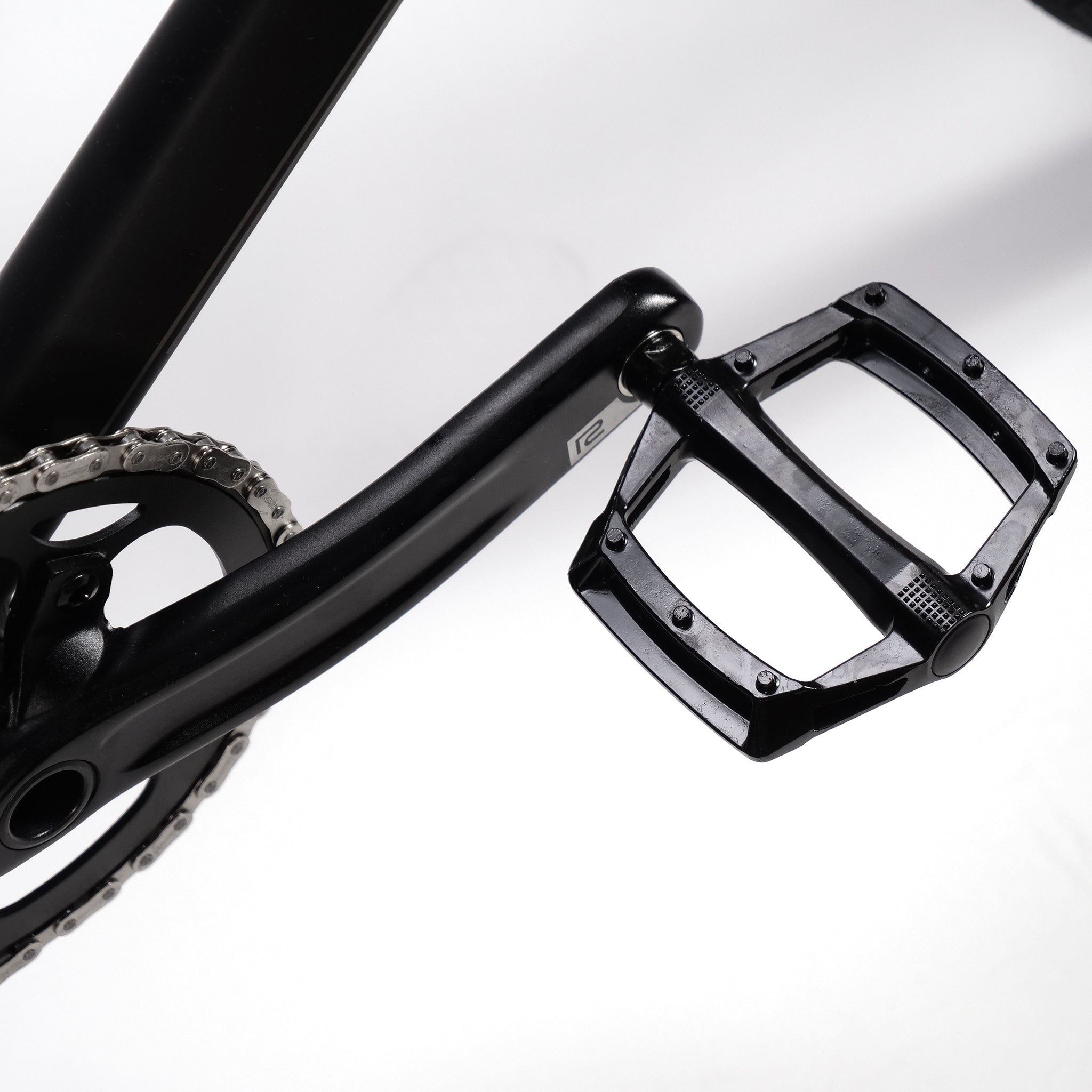 Close-up of a black bicycle crank and pedal against a white background, showcasing the Radio Quartz Pro XXL Bike 2025 with its lightweight hydro-formed frame.