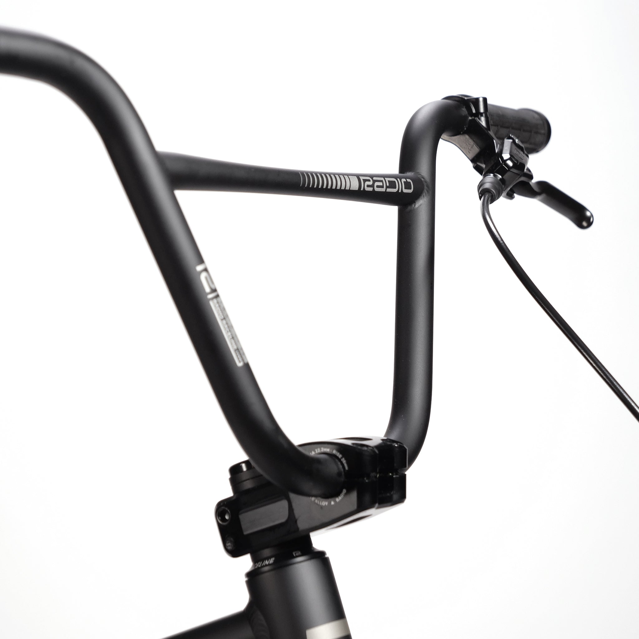 Close-up of the Radio Quartz Pro XXL Bike 2025's black handlebars with brake lever and cable, featuring branded text "REAPID" and "FREE" on the bars. Against a plain white background, the details of this sleek design highlight its compatibility with complete race bikes equipped with a carbon fork.