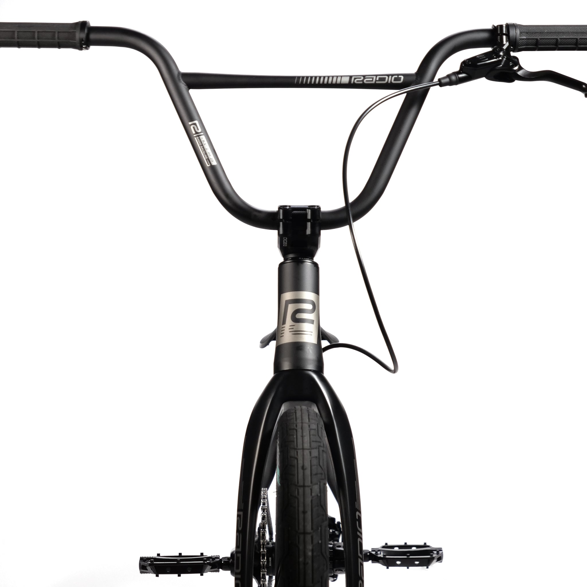 Close-up of the front view of a black race bike with wide handlebars, featuring visible Radio Quartz Pro XL Bike 2025 branding on its hydro-formed frame and handlebar.