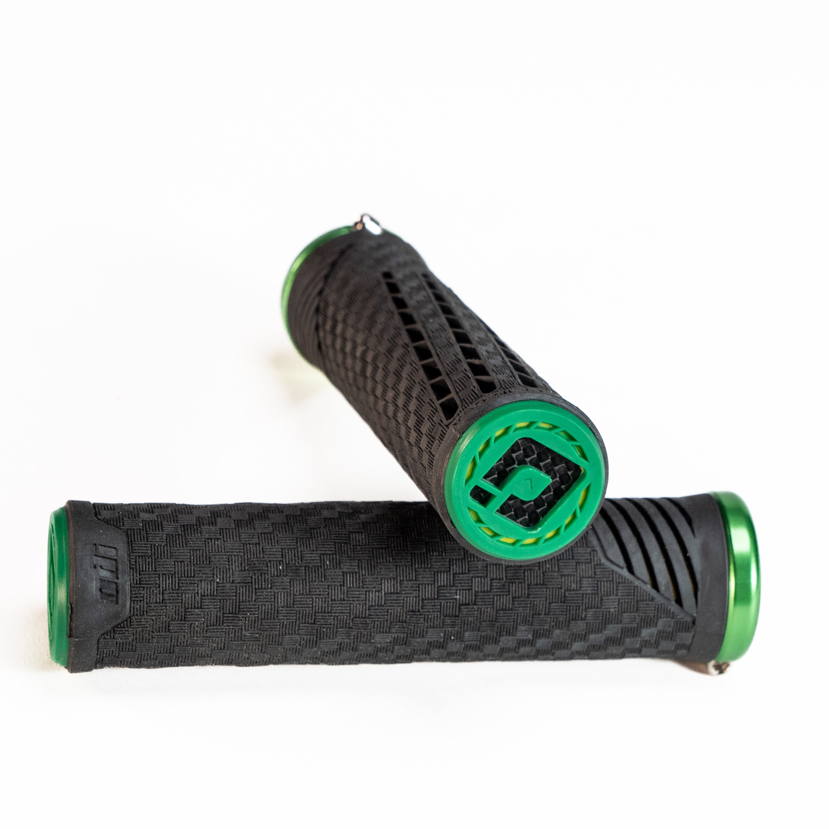 Two ODI CF Lock On Grips V2.1 Izaac Kennedy Signature, featuring black and green textured surfaces for optimized performance, placed on a white background, designed by an Olympic gold medalist.