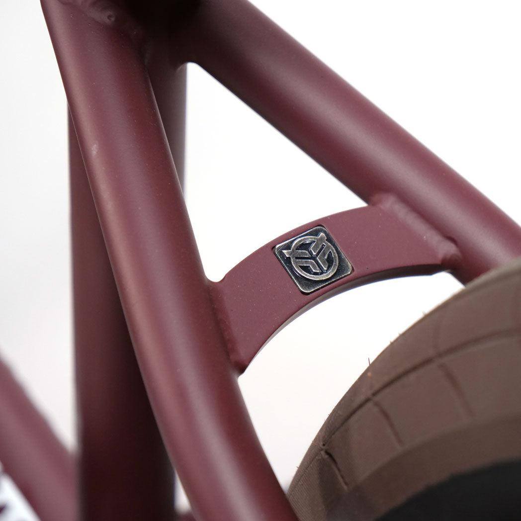 Close-up of a maroon Federal CowBoyd Custom 20 Inch Bike frame featuring an Odyssey metal emblem above the rear tire.