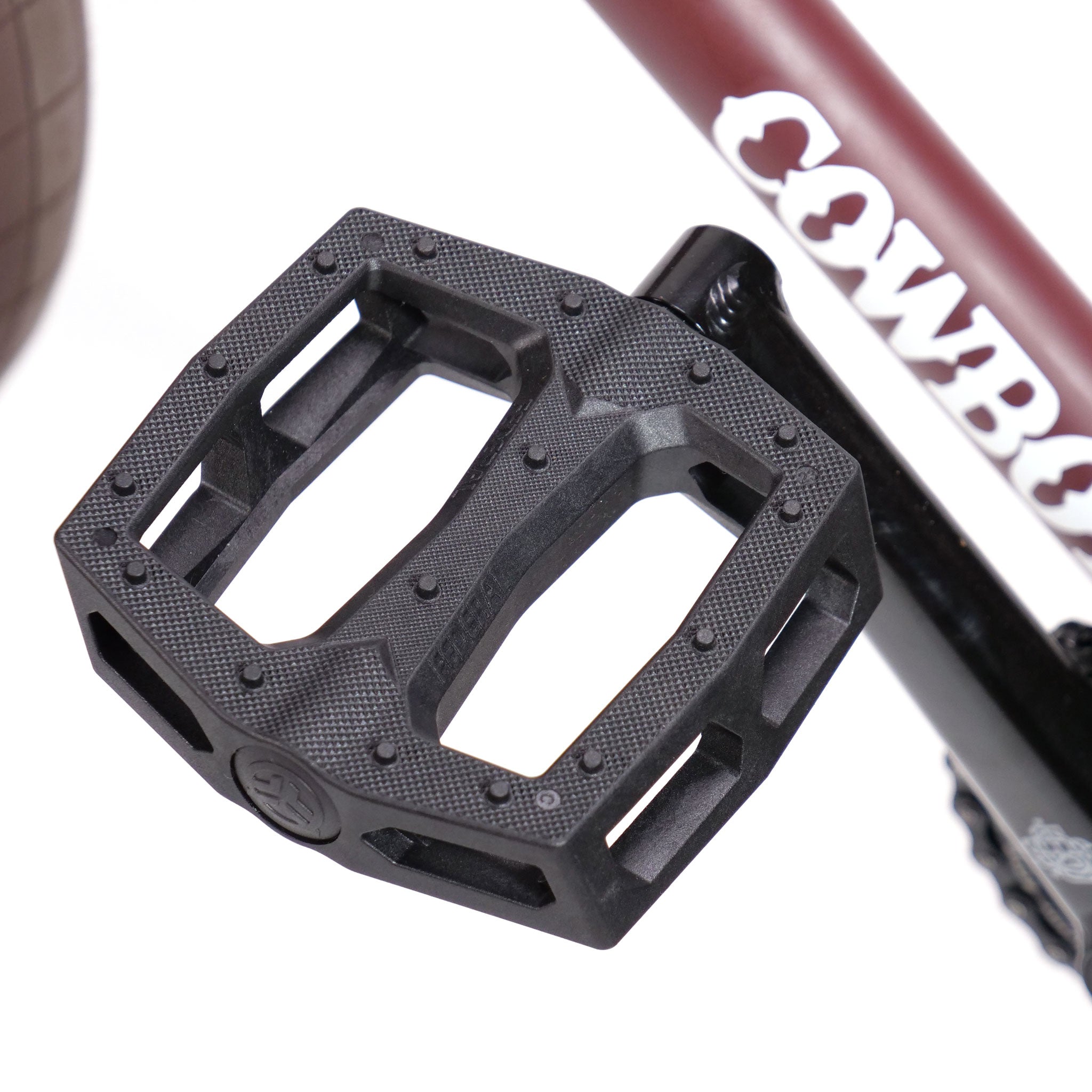 Close-up of a black bicycle pedal attached to a crank arm, with a portion of the brown frame from the Federal CowBoyd Custom 20 Inch Bike and the word "Odyssey" prominently visible.