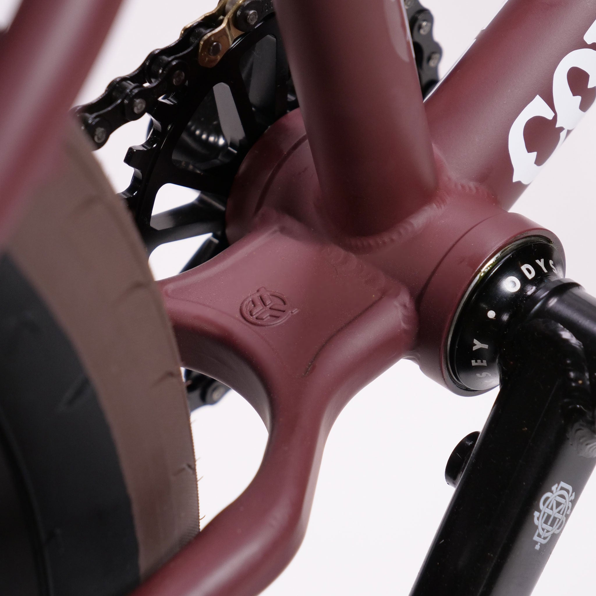 Close-up of a Federal CowBoyd Custom 20 Inch Bike frame showcasing the bottom bracket and part of the chainring. The matte maroon finish elegantly contrasts with the visible logo.