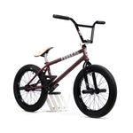 Introducing the YOUNGBOYD Custom 18 Inch Bike: This maroon BMX bike showcases black handlebars and tires, complemented by a white seat and stand. Inspired by Boyd Hilder, it’s crafted for freestyle enthusiasts who value both performance and style.