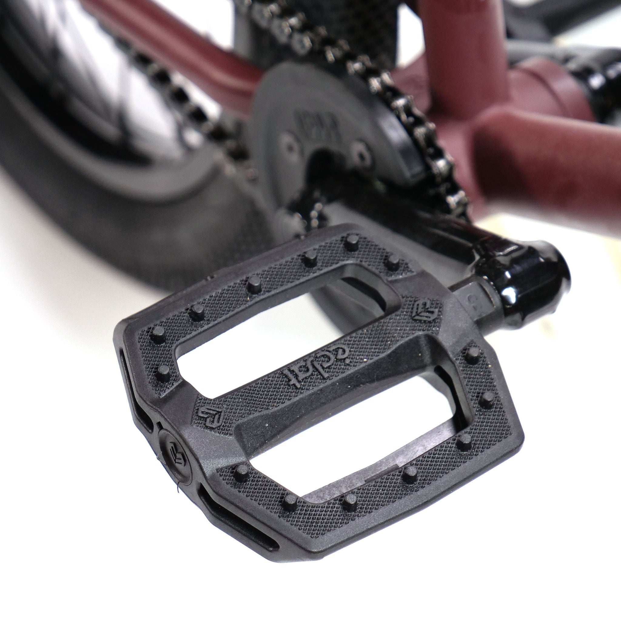 Close-up of a black bicycle pedal on the Federal YUNGBOYD Custom 18 Inch Bike, featuring an 18-inch maroon frame with visible chain and wheel components, highlighting detailed craftsmanship and aftermarket parts.