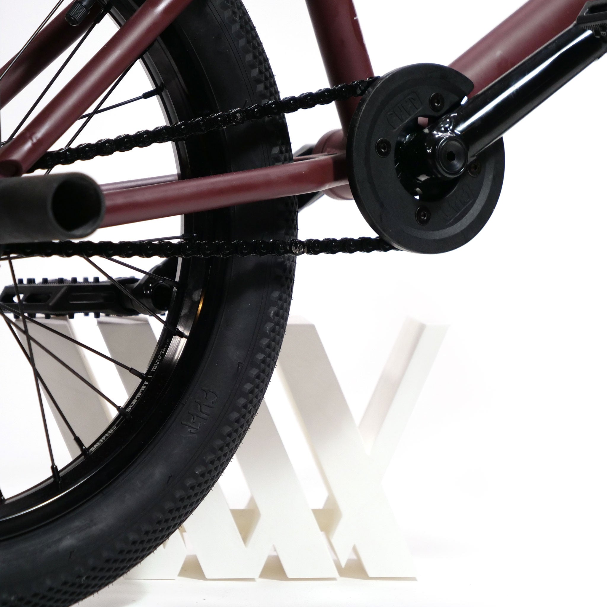 Close-up of the rear wheel and chain of a Federal YUNGBOYD Custom 18 Inch Bike equipped with freestyle aftermarket parts. A "MAX" bike stand holds the frame, set against a pristine white background.