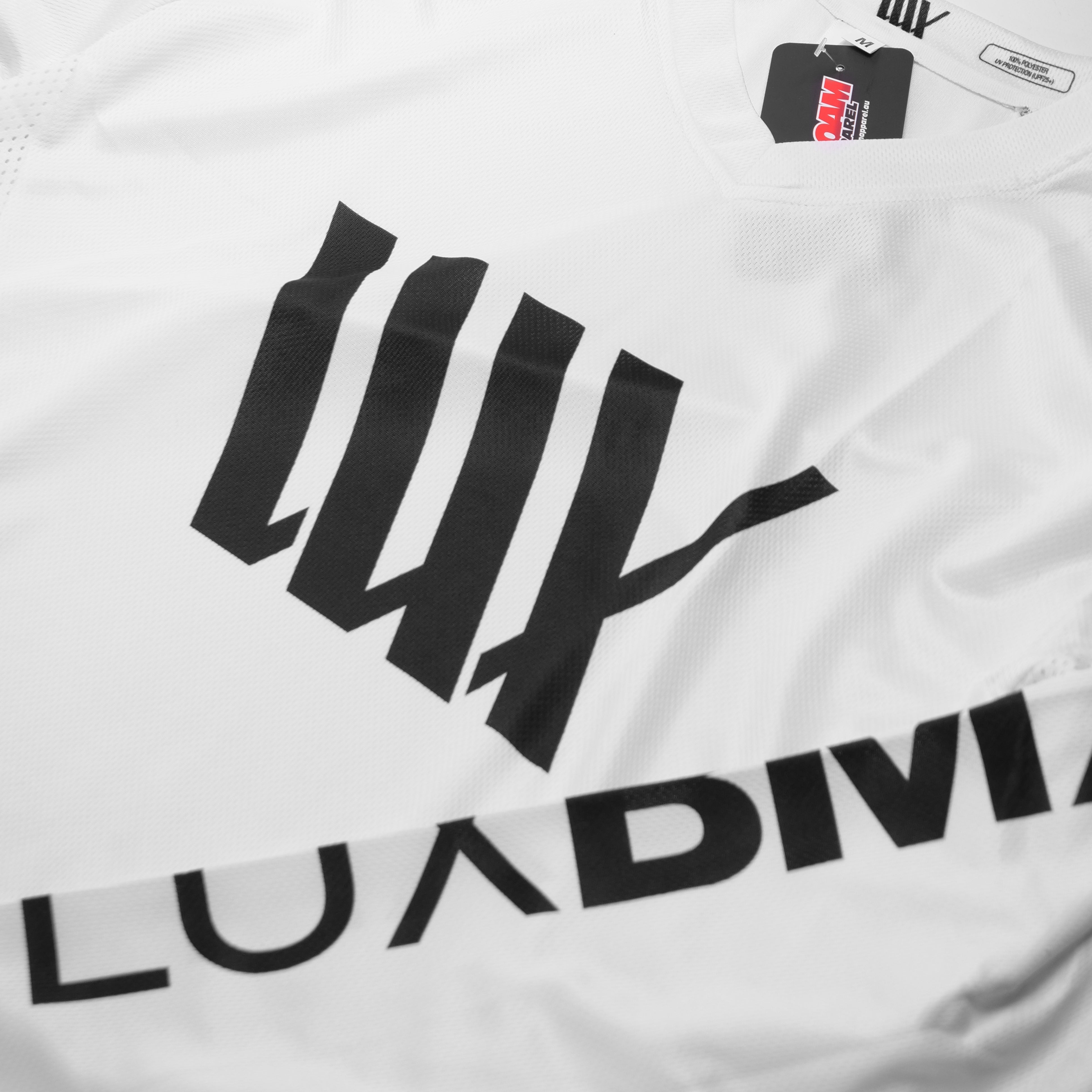 Close-up of a LUXBMX Race Jersey White V2 featuring bold black "LUXDIVA" lettering and a collar tag.