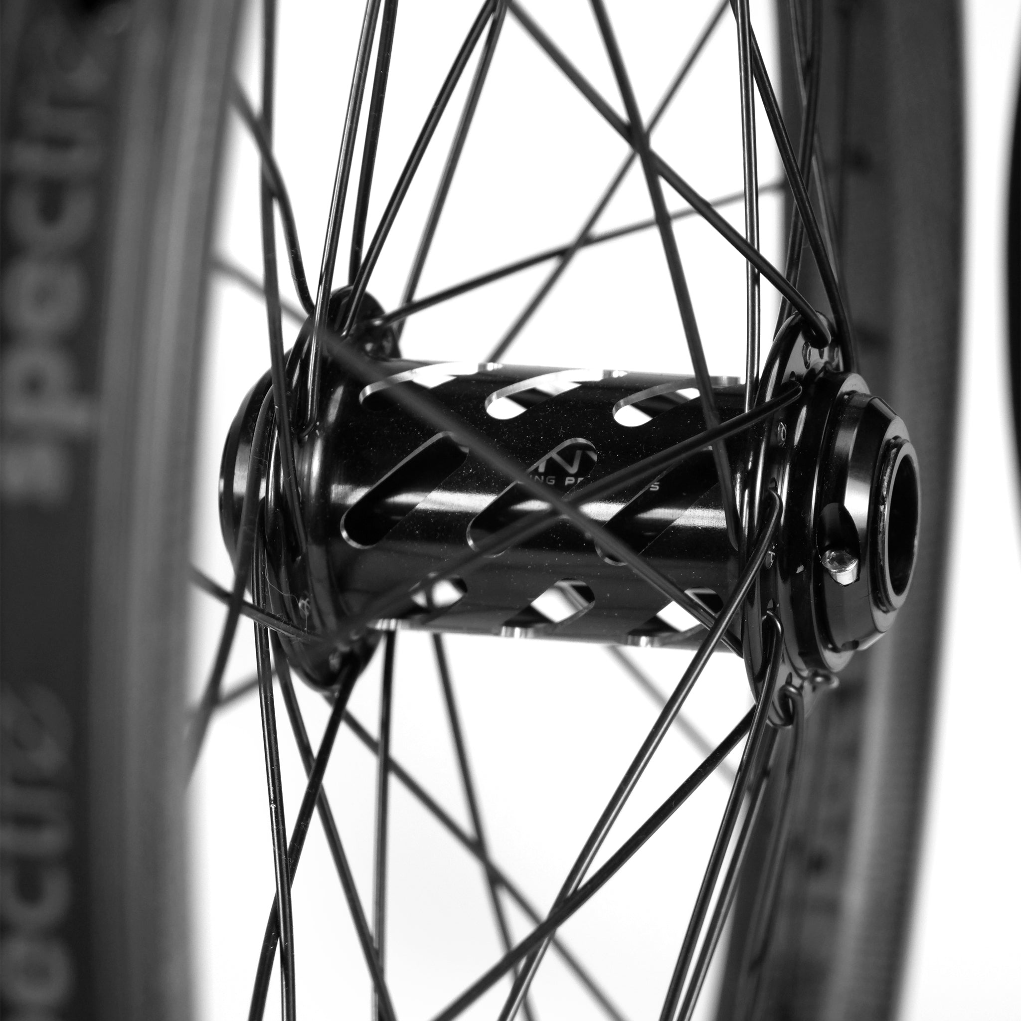 A close-up of the Onyx X Spectre's Battlesnake Black 20-inch wheelset showcases black hubs and radiating spokes, paired with sleek carbon fiber rims against a neutral backdrop.