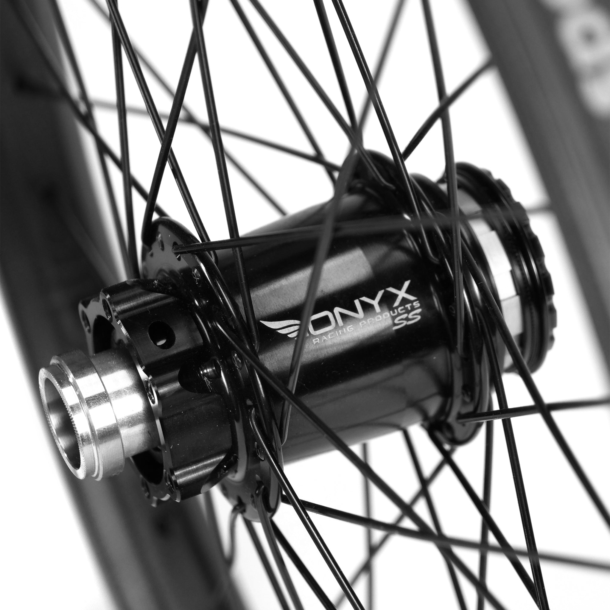 Close-up of the Onyx X Spectre Carbon Battlesnake Black 20 Inch Wheelset, showcasing a bicycle hub with black spokes and metallic finish, complemented by sleek carbon fiber rims for a premium touch.