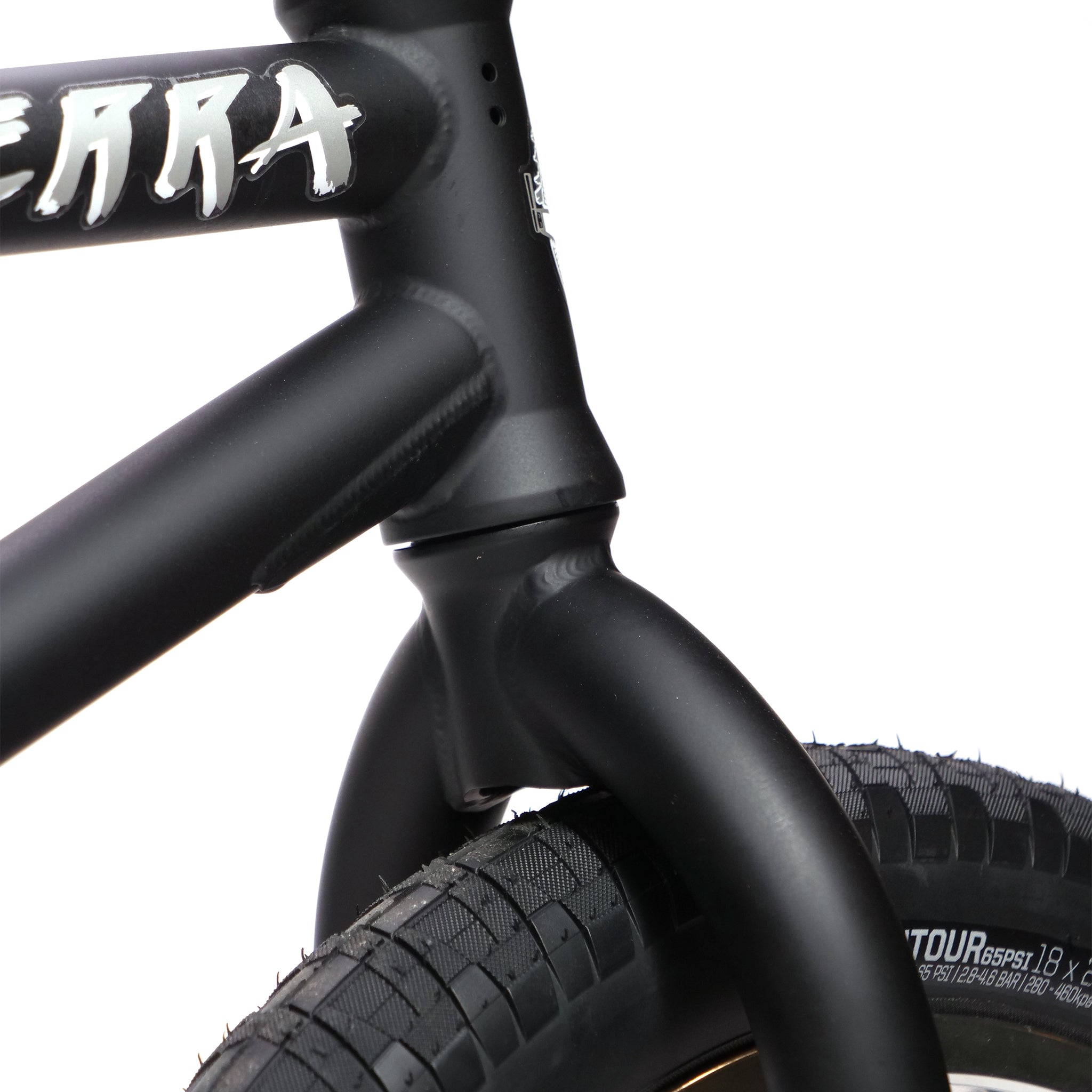 Close-up of the Fly Bikes Pajarito Custom 18 Inch BMX bike's front tire and frame featuring bold white branding on its matte black frame.