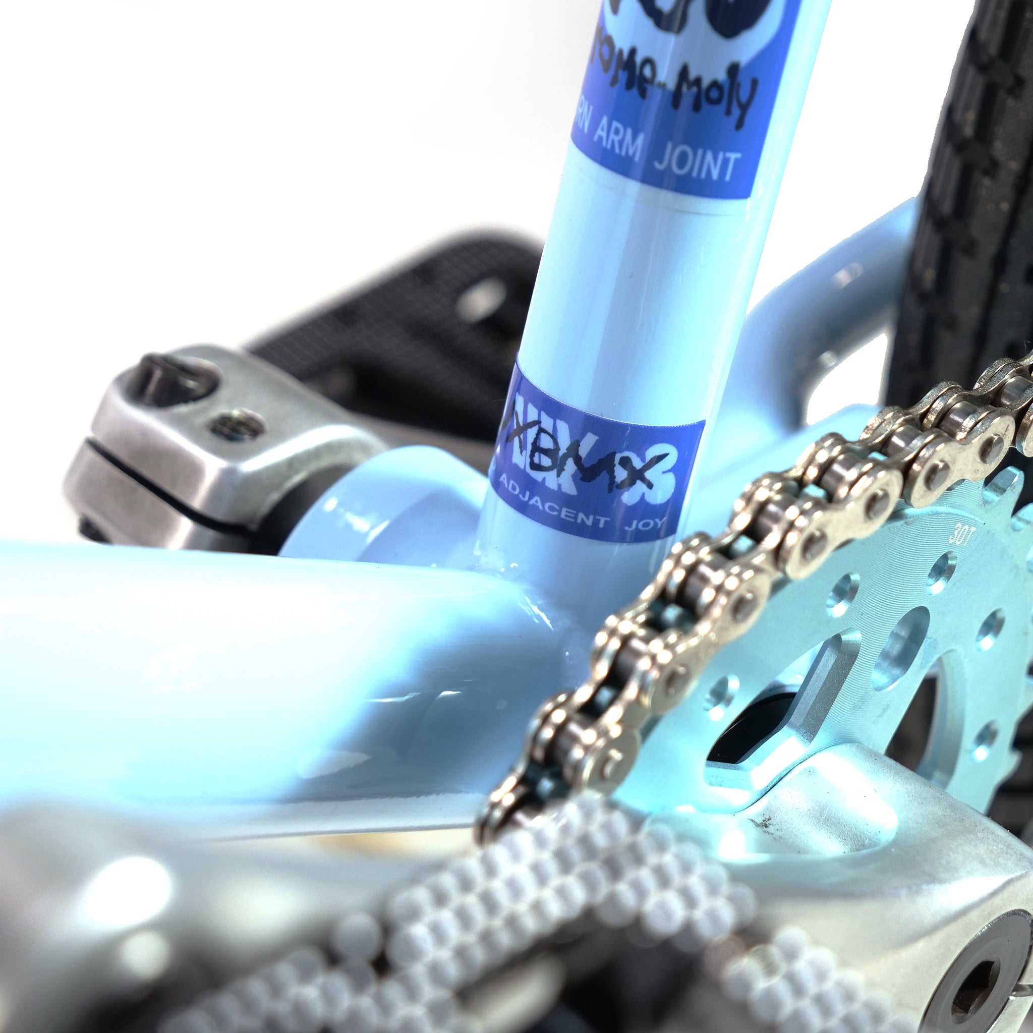 Close-up of the chain and gear mechanism on a light blue Hoffman TAJ Trend Adjacent Joy 20 Inch Custom BMX bike, showcasing iconic design and branding.