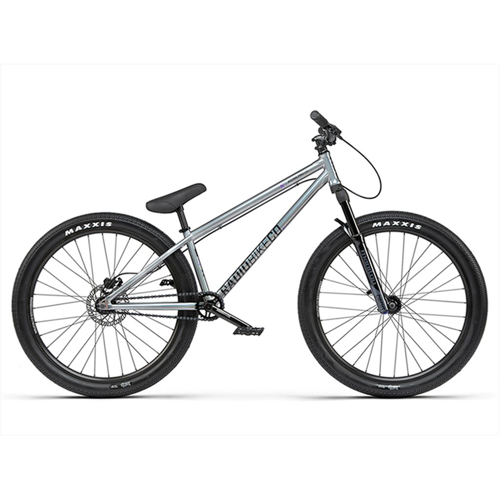 The Radio 26 Inch Asura Pro Bike boasts a sleek silver BMX design with black tires branded with Maxxis, featuring a sloped top tube, flat handlebars, and a single gear setup. This model excels due to its robust dirt jump frame and precision hydraulic disc brake system.