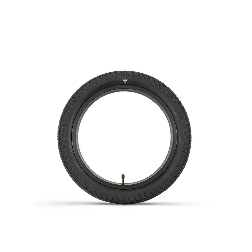 The Fly Bikes Ruben 16 Inch Tyre, with a pinch-resistant layer, features a sleek black rubber design and simple tread pattern. Seen side-on against a white background, this BMX-inspired tire is noted for its durability and stylish appearance.