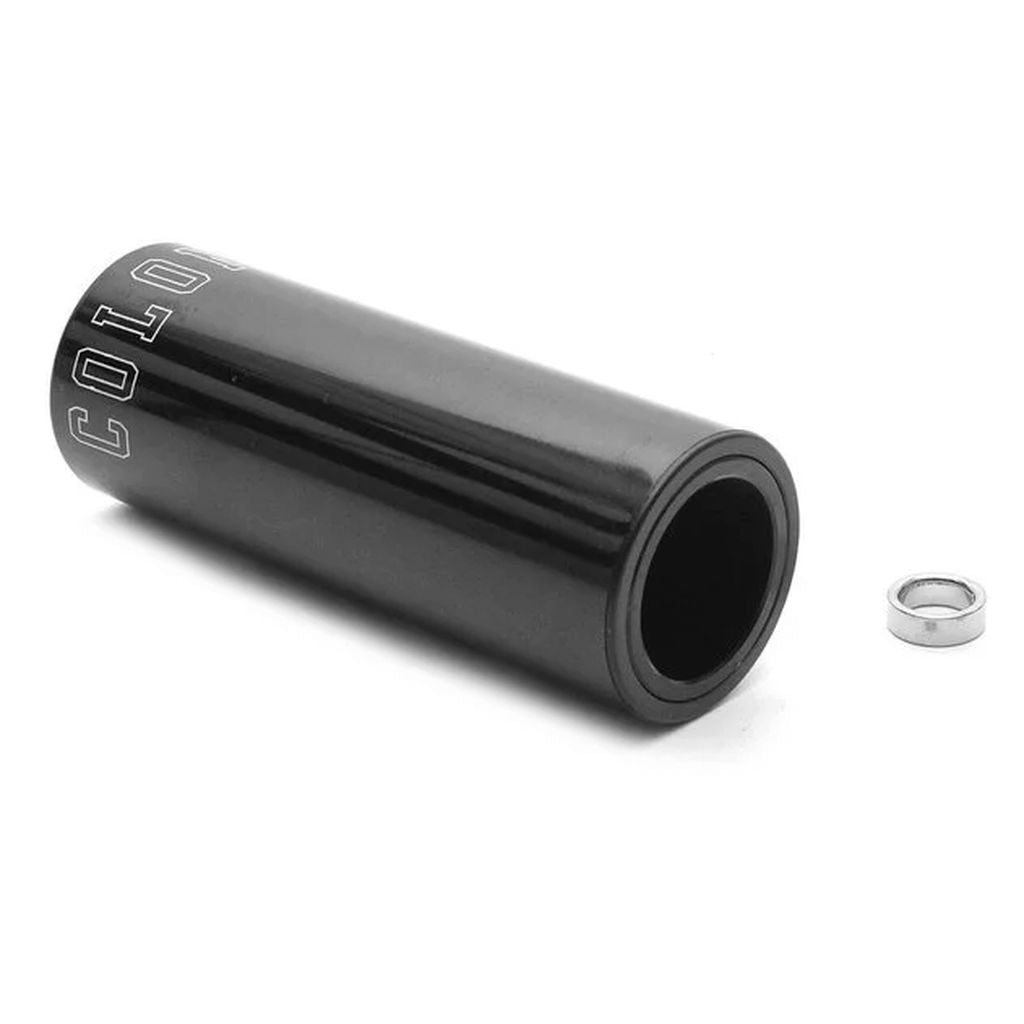 A single black cylindrical bike peg crafted from 7075 T6 Alloy, featuring the "COLONY" branding, lies beside a small metal washer.