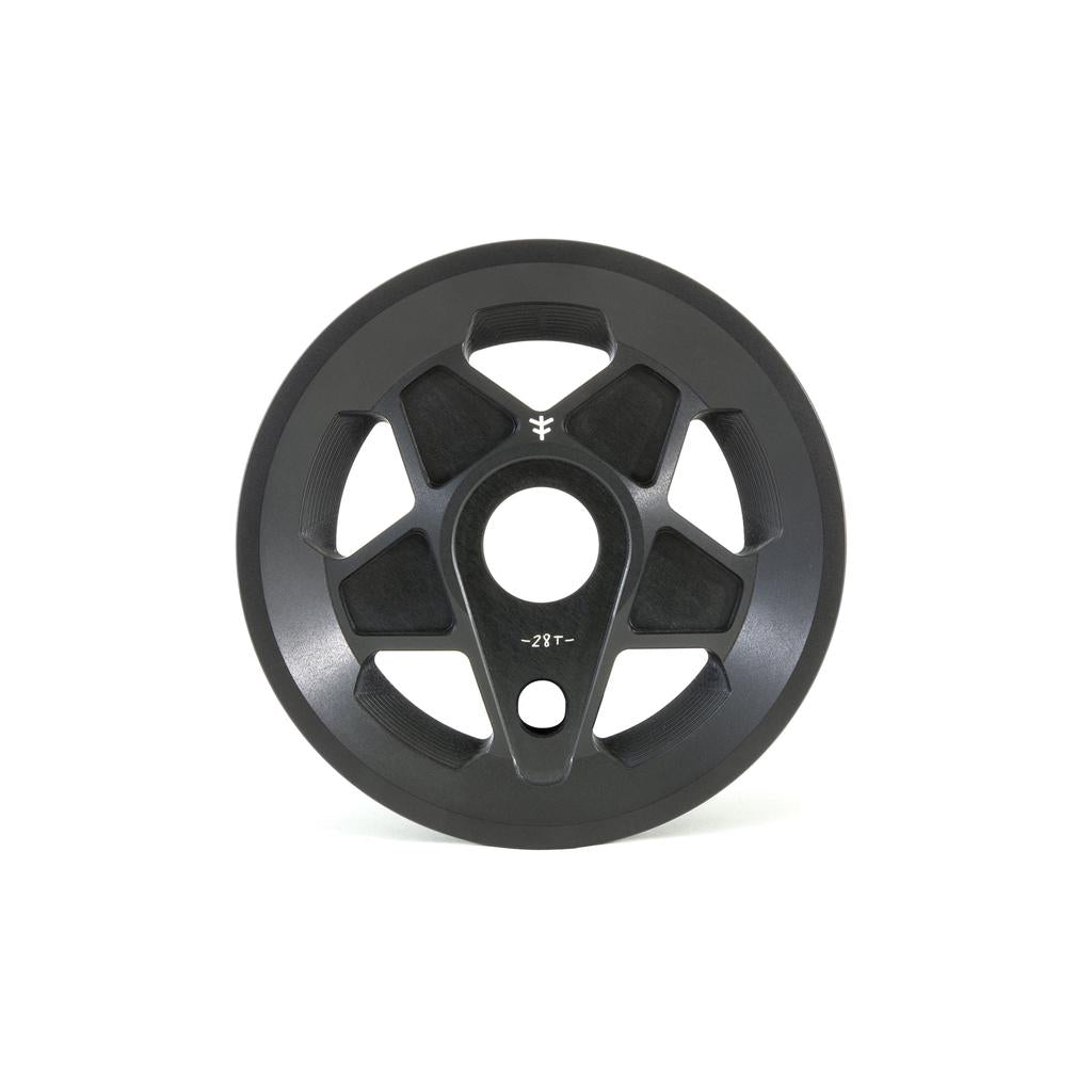 The black circular scooter wheel is made from CNC machined 6061 Aluminum with a solid core, five cut-out sections, and a small logo. Its sleek surface resembles the design of the Fly Bikes Tractor Guard Sprocket.